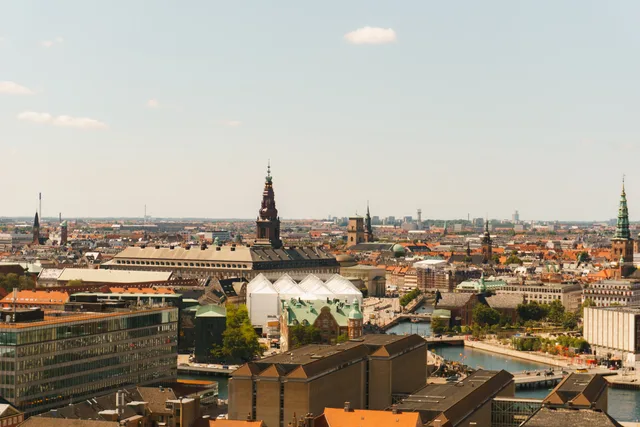 Panoramic aerial view of Copenhagen's historical architecture and waterways under a clear sky. Sådan finder du markedets geografiske afgrænsning i dansk statistik